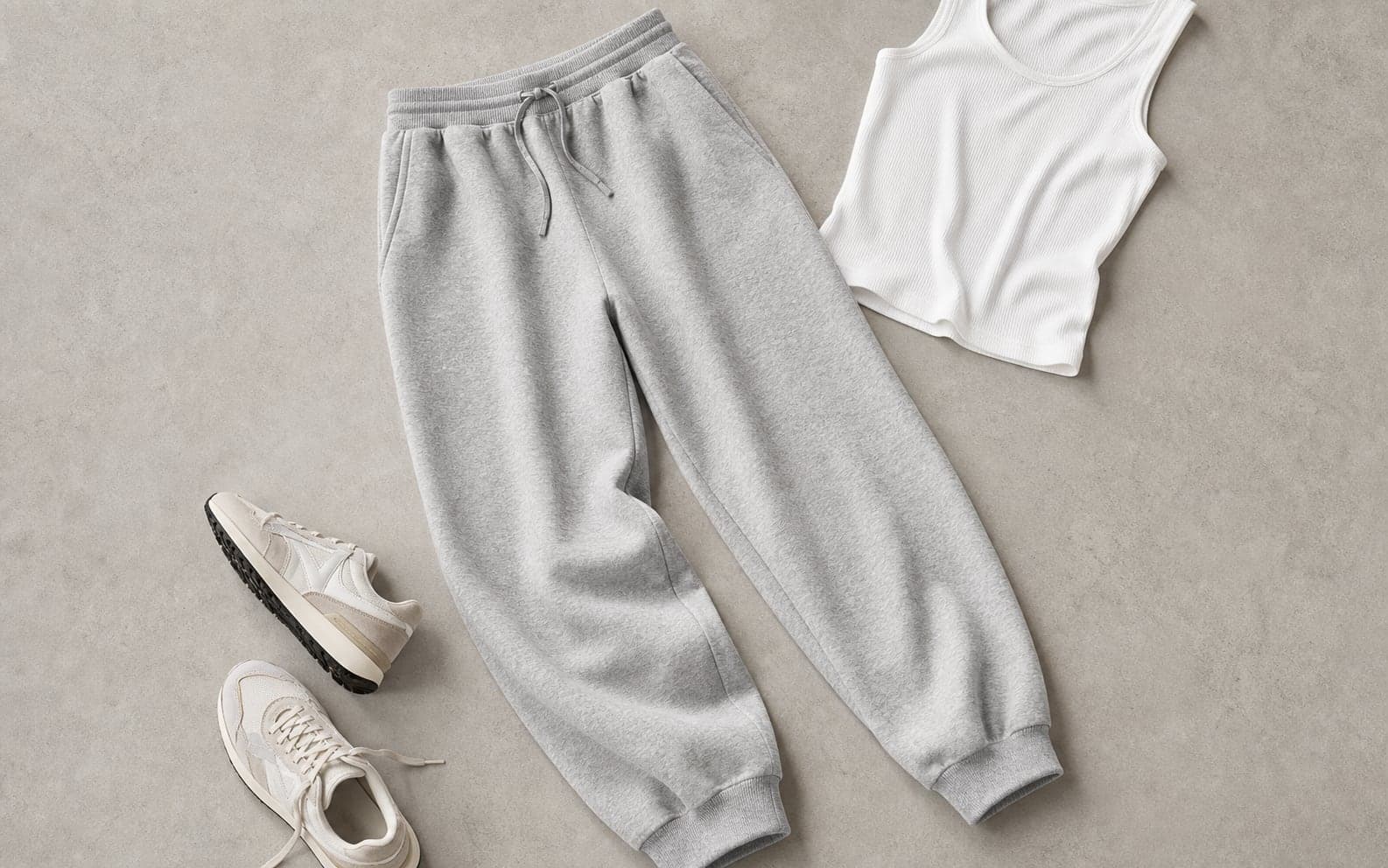 Structured heather gray relaxed sweatpants styled with a white ribbed tank and cream sneakers.