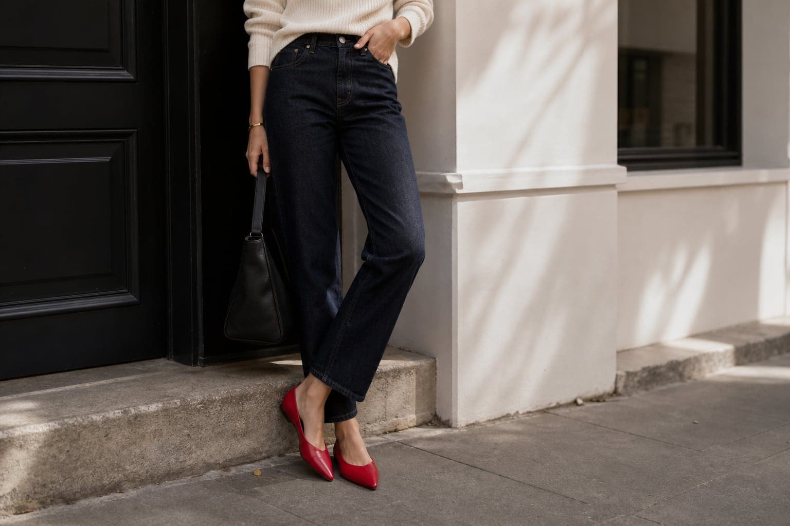 Red pointed flats styled with dark straight jeans and an ivory knit.