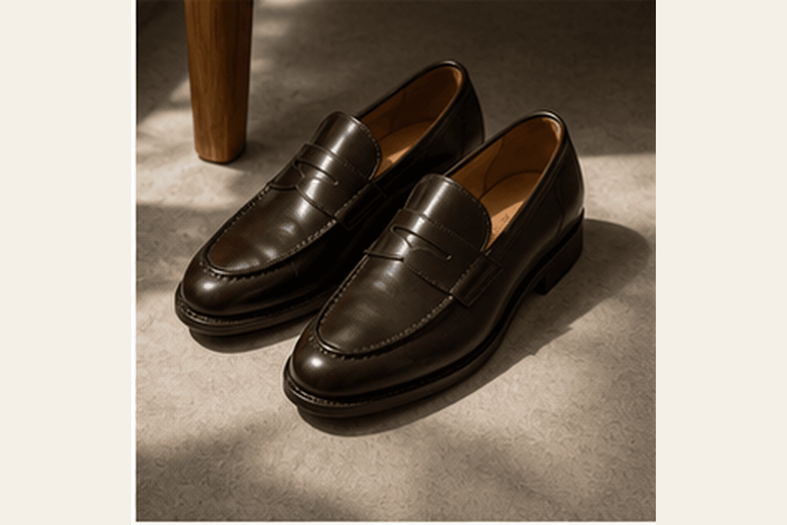 Dark brown leather loafers photographed in soft natural light.