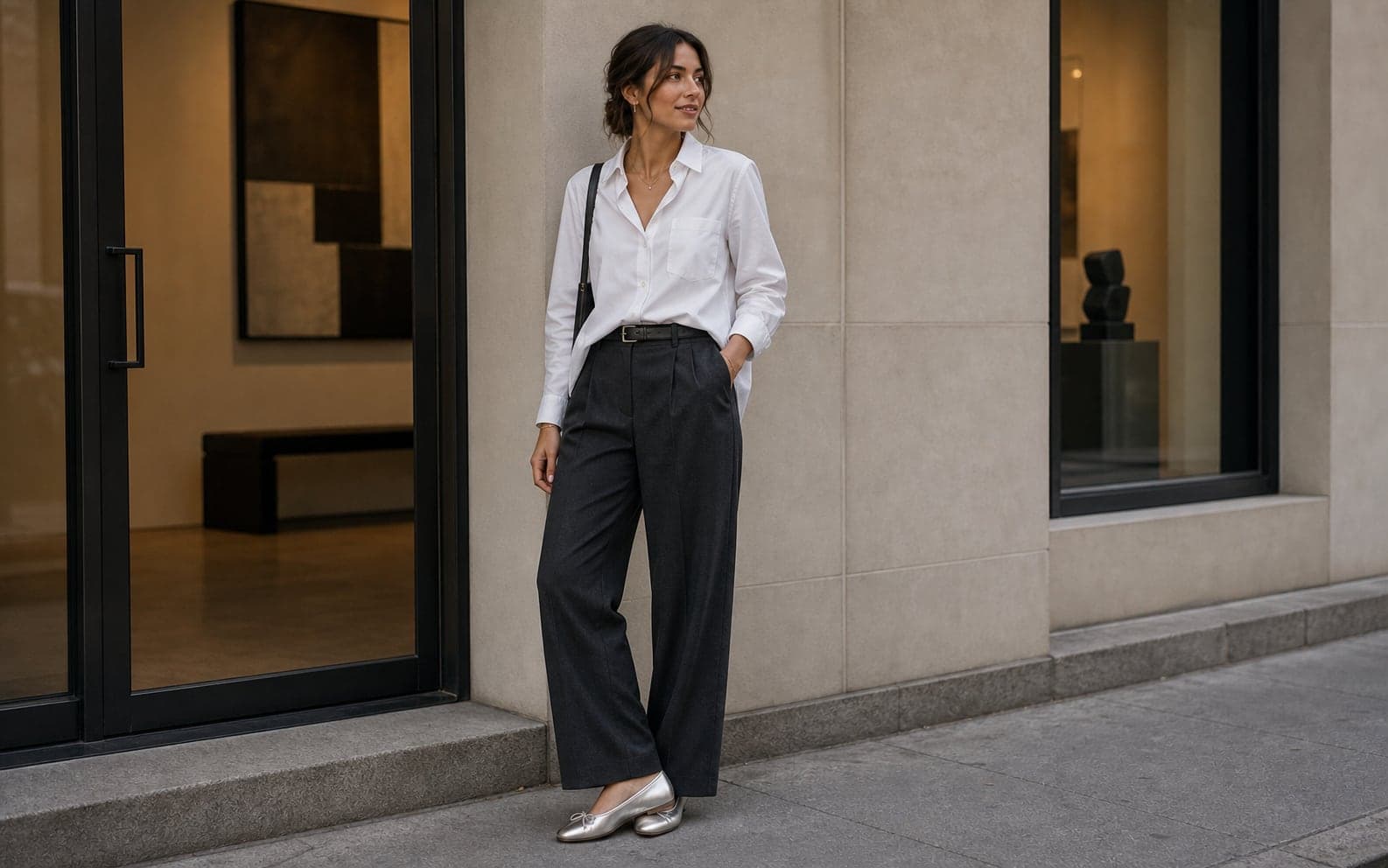 Woman in dark trousers and a white shirt with metallic silver flats as the intentional off-color shoe.